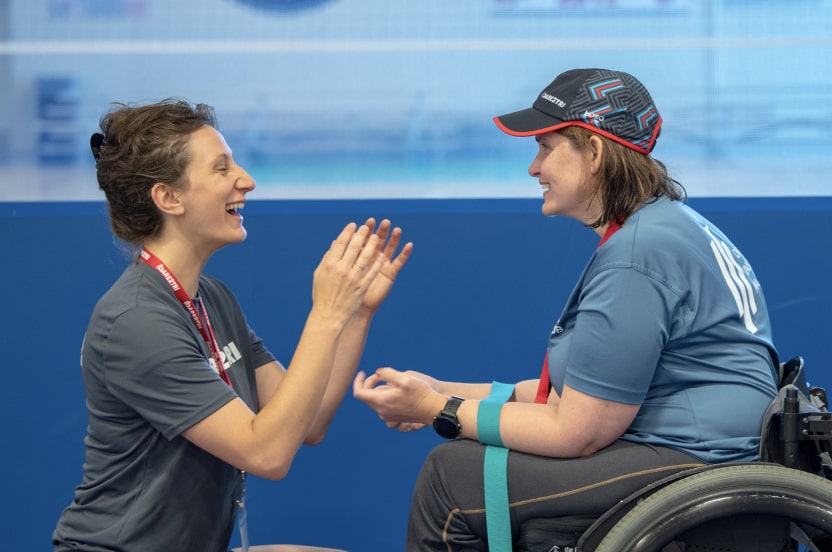 A coach helps a Dare2tri athlete during a training exercise.