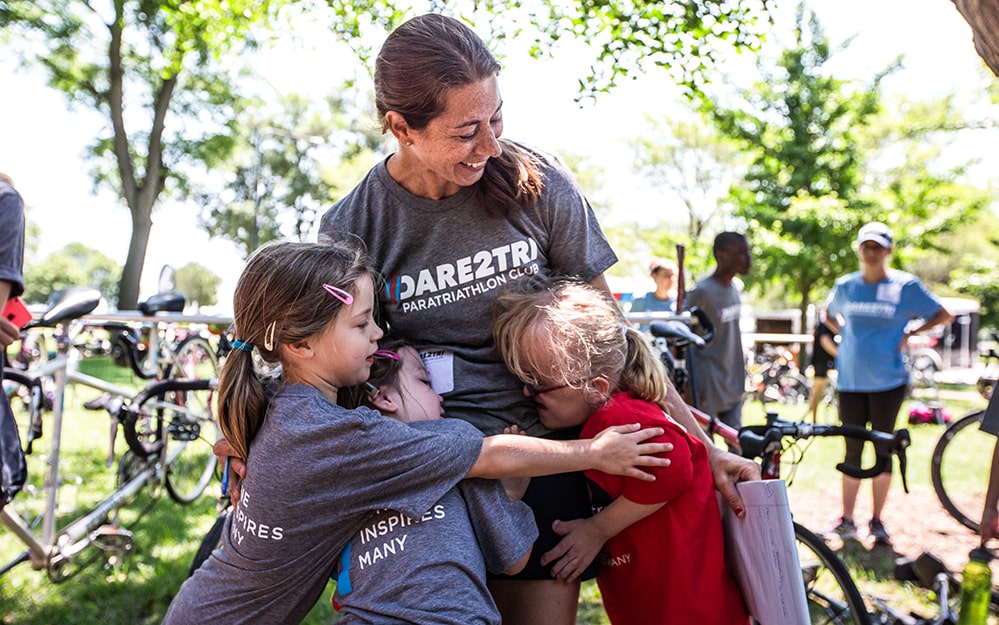 Dare2tri Executive Director receives a group hug from youth athletes.