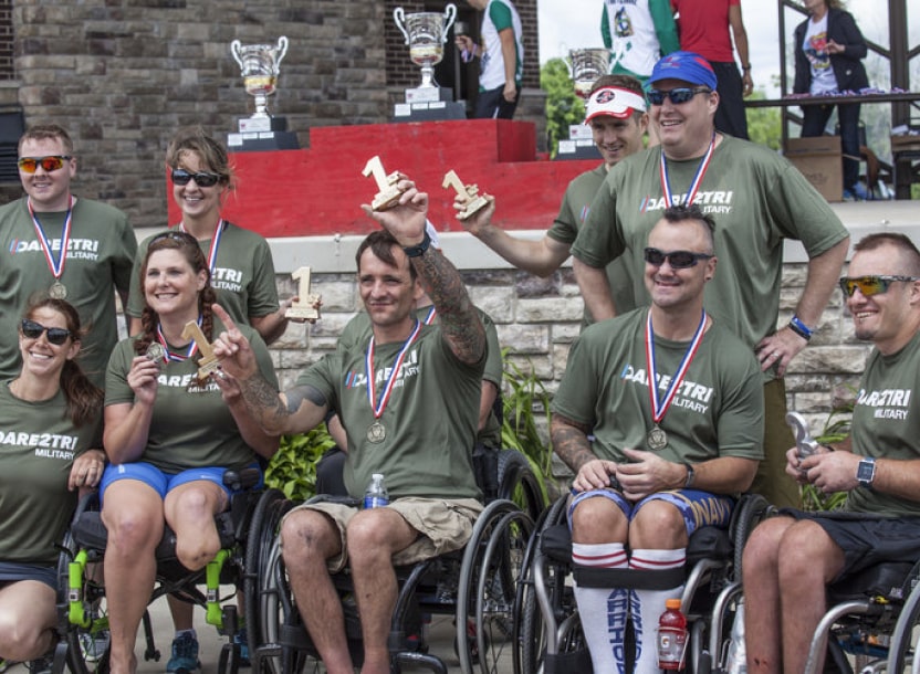 Athletes hold up their awards after Leon's Triathlon