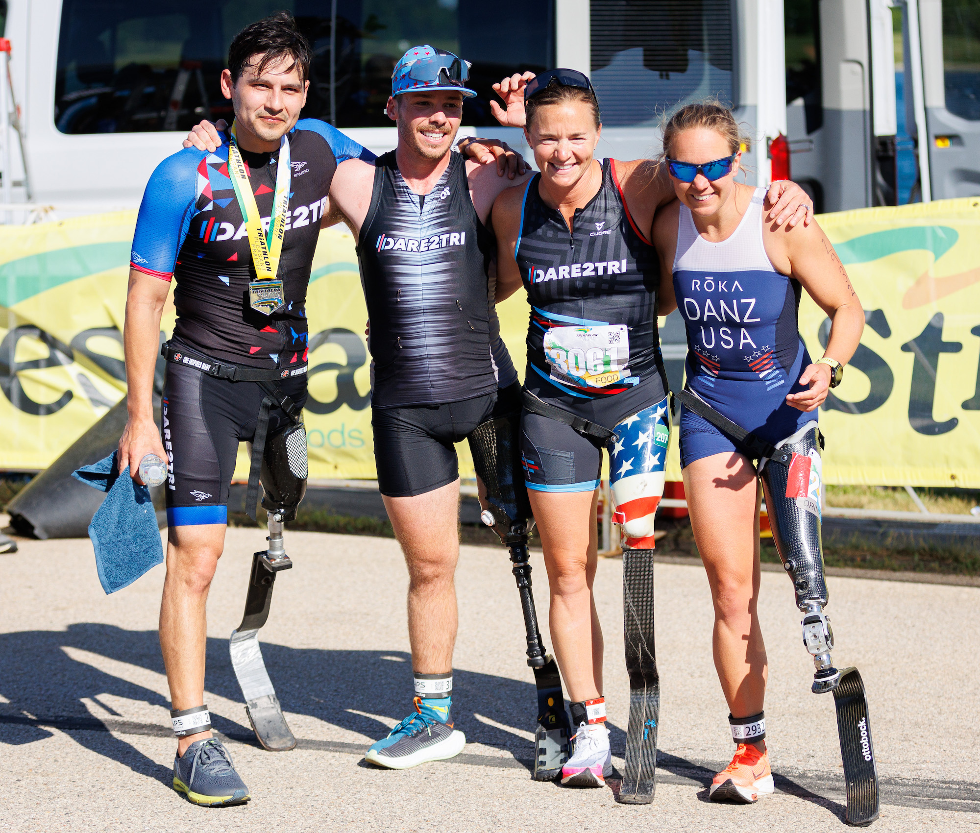 Four athletes standing who have prosthetic legs: Jorge Torres, Kyle Stepp, Melissa Stockwell and Hailey Danz.