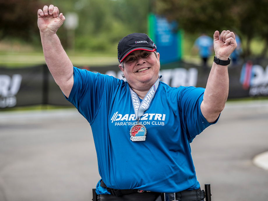 dare2tri athlete with arms raised finishing race