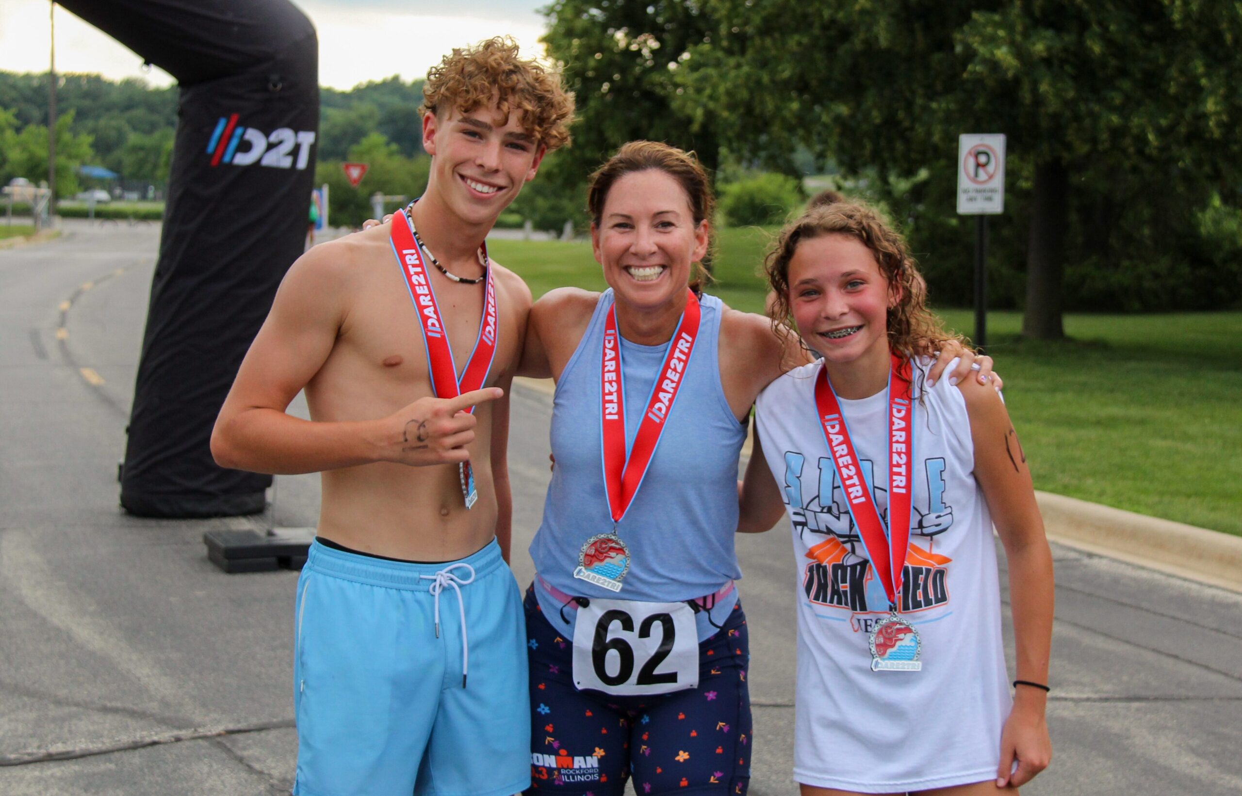 A team of three wearing race medals.
